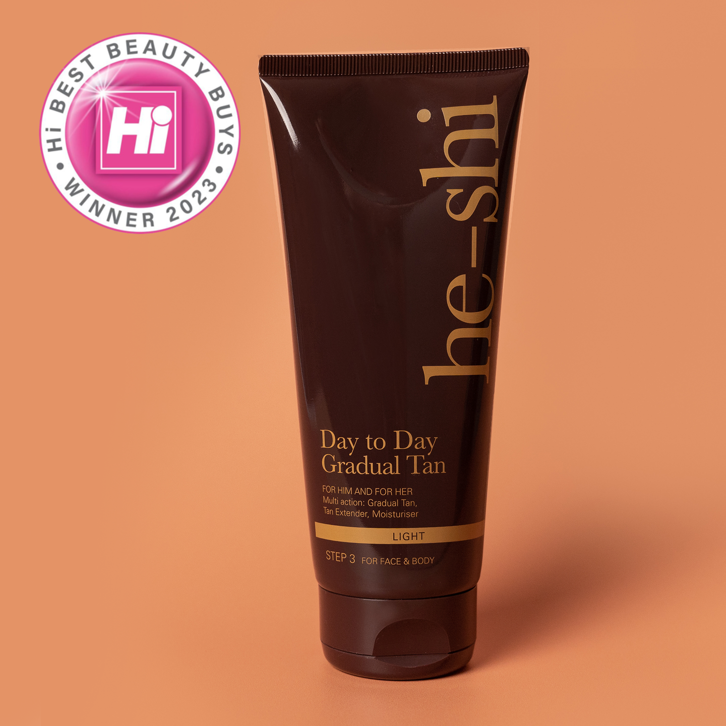 Tube of 'he-shi' Day to Day Gradual Tan on an orange background with a 'Hi Best Beauty Buys 2023' badge.