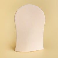 Image of He-Shi tanning mitt on a light yellow background