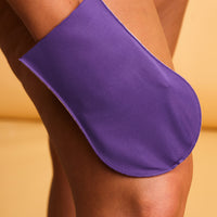 Woman pressing He-Shi tanning mitt to her leg