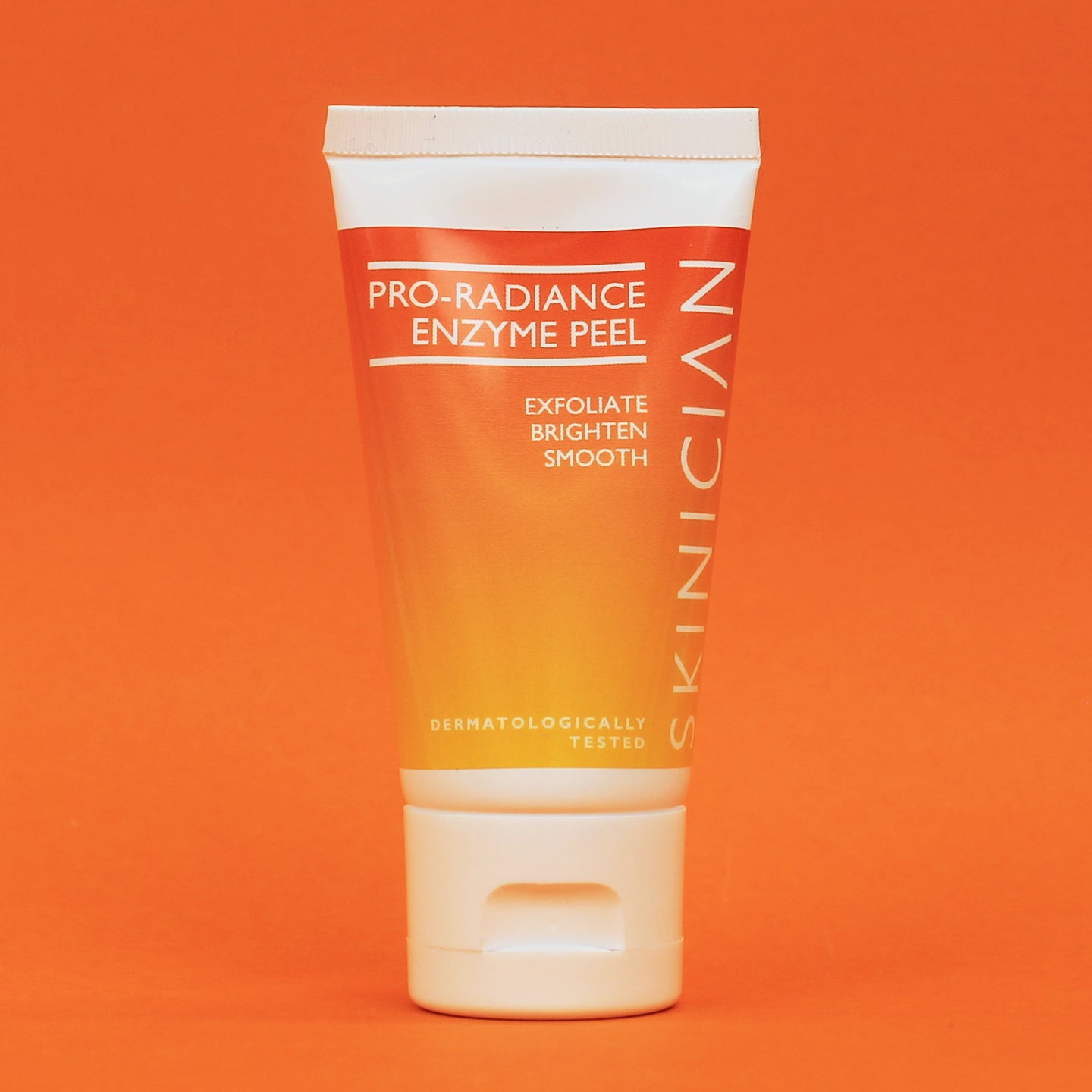 Tube of Skinician Pro-Radiance Enzyme Peel on an orange background