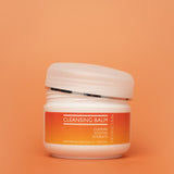 Cleansing balm jar with orange label on an orange background