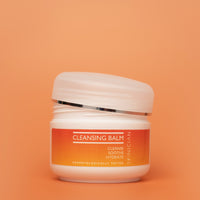 Cleansing balm jar with orange label on an orange background